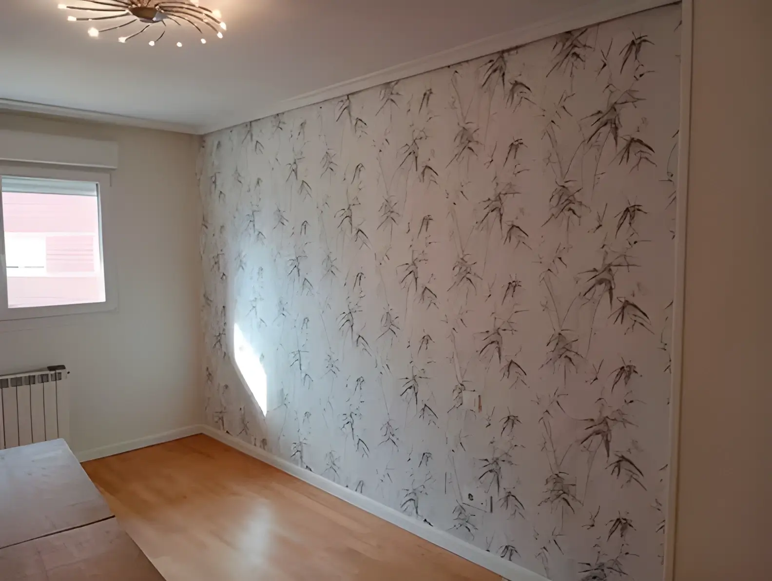 Los Pintores en Sevilla colocando papel pintado en pared de acento de habitación luminosa