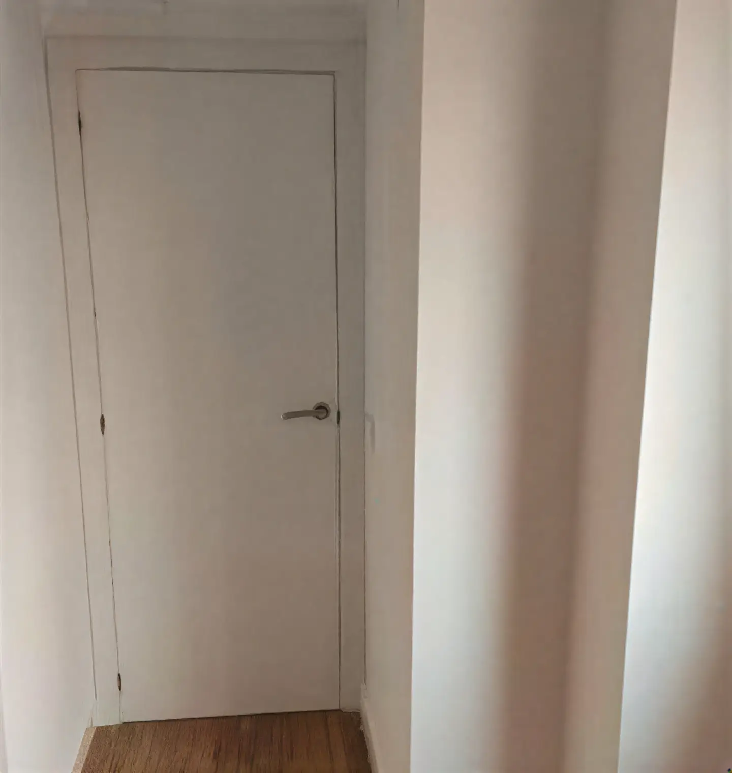 Puerta interior lacada en blanco en pasillo realizada por Los Pintores en Sevilla
