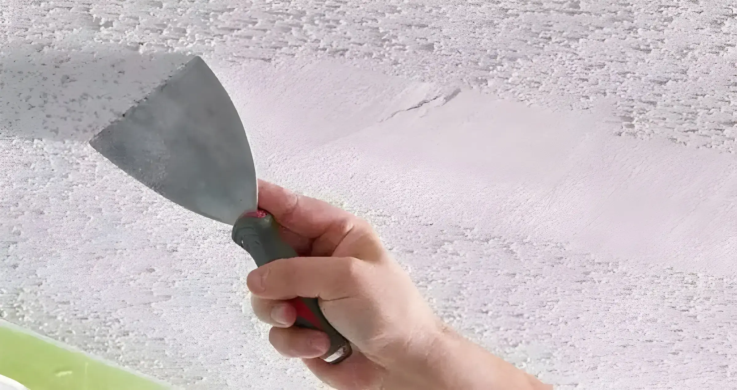 Los Pintores en Sevilla eliminando el gotelé con espátula para dejar la pared lisa